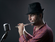 stock-photo-44079036-man-playing-orchestral-flute-on-old-fashioned-microphone